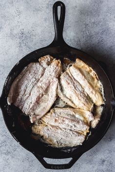 pork chops in a cast iron skillet with powdered sugar on the top