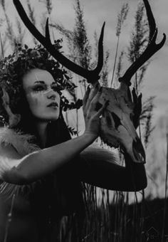 a woman holding a deer's head in front of her face