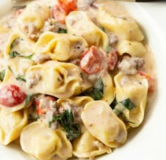 a white bowl filled with pasta and meat