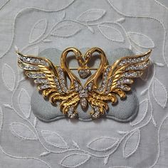 "A beautiful statement brooch by Nolan Miller with two swans forming and holding a heart drop encrusted with clear crystals on gold plated metal Signed Size: 8 x 4.3 cm / 3.1\" x 1.7\" International shipping takes 5-7days Please refer to photos as part of description and message for more information" Swan Wings, Two Swans, Swan Jewelry, Statement Brooch, Nolan Miller, Holding A Heart, River Pearls, Locket Pendant Necklace, Heart Brooch