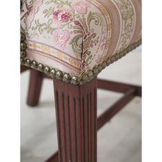 an upholstered chair with beaded trimming