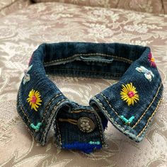 an old pair of jeans has been decorated with flowers and beads on the inside of it