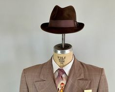 "You'll need this snazzy 1950's fedora to complete your look and turn your suit into an outfit! This fur felt fedora is chocolate brown with a cedar brown grosgrain ribbon band. It has a leather hat band and is fully lined. Made by \"Biltmore\" and sold by \"The Hat Guys\" in Oakland California. This hat is in great vintage condition with no holes, stains, or odors to note. Marked Size: 7 Inner circumference: 22\" Length (at longest point): 11.5\" Width (at widest point): 10.5\" Crown Height: 4\ Brown Fitted Fedora For Kentucky Derby, Formal Fitted Brown Fedora, Retro Fitted Fedora With Curved Brim, Retro Fedora With Curved Brim, Fitted Retro Fedora With Curved Brim, Vintage Fitted Hat Bands For Fall, Retro Fitted Brimmed Fedora, Vintage Fedora With Wide Brim, Vintage Fitted Fedora With Flat Brim