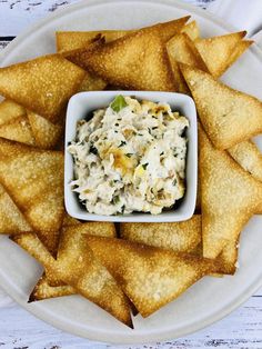 a white plate topped with tortilla chips and dip