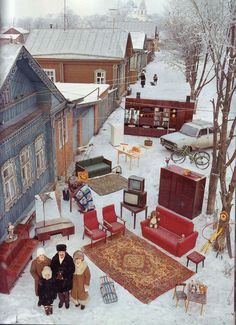 two people are standing in the middle of a snow covered yard with furniture and antiques