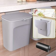 a gray trash can hanging from the side of a kitchen counter