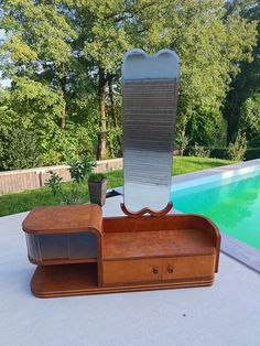 a wooden desk with a mirror on it next to a pool