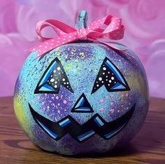 a painted pumpkin sitting on top of a wooden table