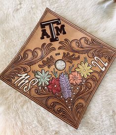 a brown book with flowers and letters on it