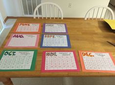 a wooden table topped with calendars on top of it