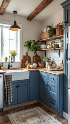 a kitchen with blue cabinets and wooden shelves on the wall, an area rug in front of the sink