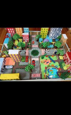 a toy city with cars and buildings on the street is shown in this image, it appears to be made out of cardboard