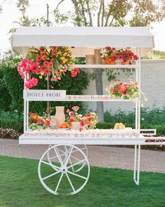 a white cart with flowers and fruit on it