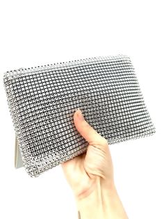 Looking for a stylish and practical clutch bag that you can use for any occasion? Our Rhinestone clutch bag is all you need! This stunning bag is the perfect accessory for any outfit, whether heading to a business meeting, a night out with friends, or a special event.  - Glittering rhinestones that catch the light and add a touch of glamour to your look - A convenient wristlet strap that makes it easy to carry and keeps your hands free - A compact size that's perfect for essentials like your phone, keys, and wallet - A secure zipper closure that keeps your belongings safe and secure - Versatile design that works for any occasion, from formal events to casual outings - Eye-catching style that is sure to turn heads and make you feel confident and stylish - Small size that is easy to carry an Modern Handheld Clutch For Evening, Modern Rectangular Clutch For Night Out, Trendy Pouch Clutch For Events, Modern Rectangular Evening Bag For Night Out, Silver Evening Pouch, Modern Evening Cosmetic Bag, Evening Clutch Cosmetic Bag, Modern Clutch Evening Bag For Events, Modern Evening Pouch Cosmetic Bag