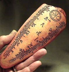 a person holding a piece of pottery with writing on it