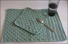 two crocheted placemats on a table with a fork and glass next to them