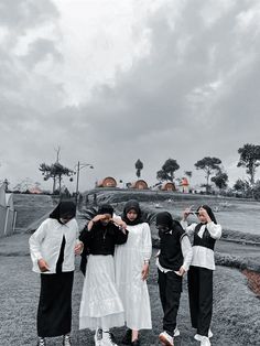 four women in black and white clothing standing together