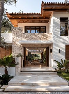 the entrance to a modern home with stone steps leading up to it's front door