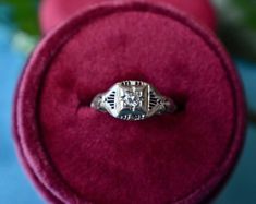 an antique diamond ring sits in a velvet box