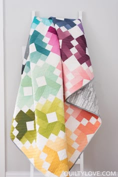 a multicolored quilt on a white chair