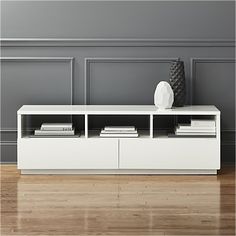 a white entertainment center sitting on top of a hard wood floor next to a wall