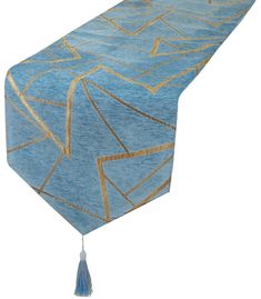 a blue table runner with gold lines and tassels on the edge, along with a white background