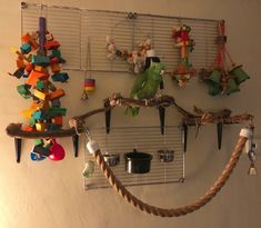 a parrot sitting on top of a wooden branch next to a bunch of toy birds