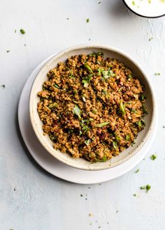 a white bowl filled with food on top of a table