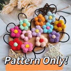 there are many crochet flowers on the wooden platter that says pattern only