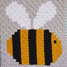 a crocheted blanket with a yellow and black bee on it's side