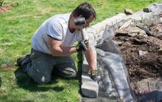 a man is working on landscaping in the yard