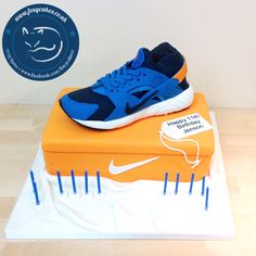 a blue and white nike shoe on top of an orange box