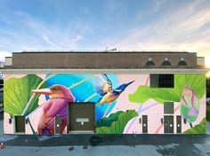 a colorful mural on the side of a building with birds and flowers painted on it