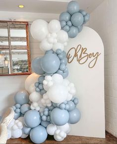 the balloon arch is decorated with blue and white balloons