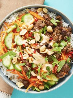 a bowl filled with rice, meat and veggies on top of a table