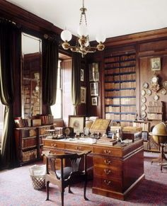 an old fashioned library with many bookshelves and desks in the middle of it