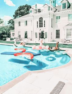 an inflatable raft floating on top of a swimming pool next to a large white house