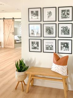 a wooden bench sitting next to a wall with pictures on it