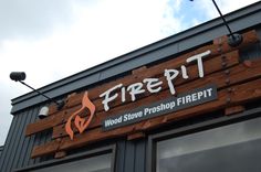 there is a fire pit sign on the side of this building that says, wood store photoshop firepit