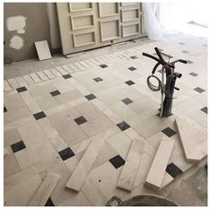 a bike is parked in the middle of a room with black and white tiles on the floor