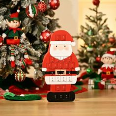 a christmas scene with santa claus and other holiday decorations on the floor next to a tree