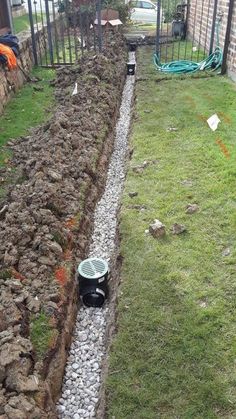 there is a small garden with rocks and gravel in the ground next to a fence