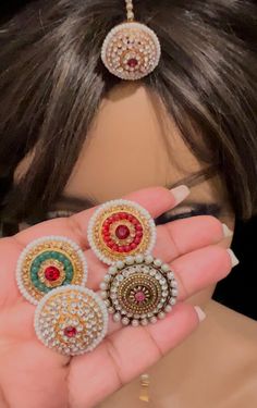 a woman is holding three pieces of broochies in front of her face,