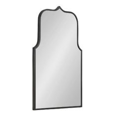 a mirror that is on top of a white wall and has an arch shaped frame