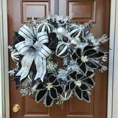 a black and white christmas wreath on a door