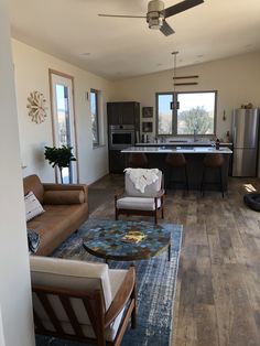 a living room filled with furniture next to a kitchen