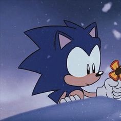 sonic the hedgehog holding a butterfly in his right hand and looking at it's left side