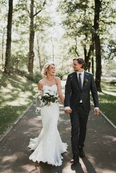 a bride and groom are walking down the path together in their wedding attire with confetti falling all over them