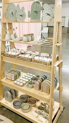 a wooden shelf filled with lots of different types of dishes and clocks on top of it