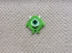 a green brooch sitting on top of a carpet